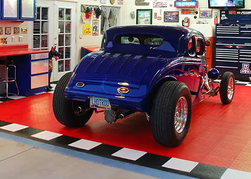 A blue hotrod coup parked in a garage with red GarageTrac